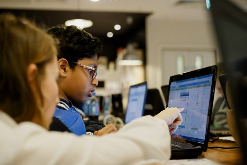 Photo: a mentor helps a child at a CoderDojo