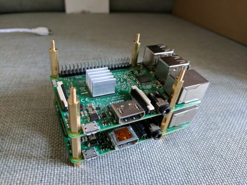 A Raspberry Pi 3 sitting atop a Pi 2 on cloth