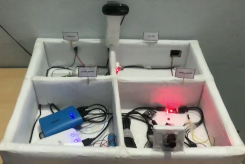 A shallow box divided into four labelled "rooms", all containing electronic components