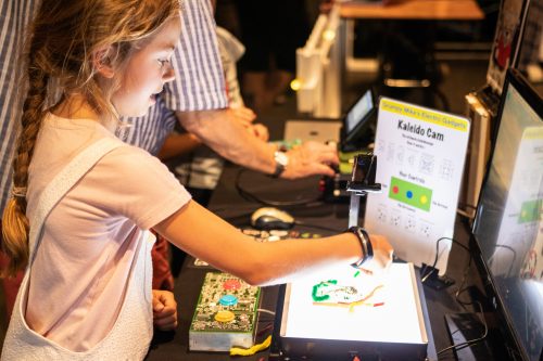 A young girl tries out a digital project at the Raspberry Pi event, Raspberry Fields 2018