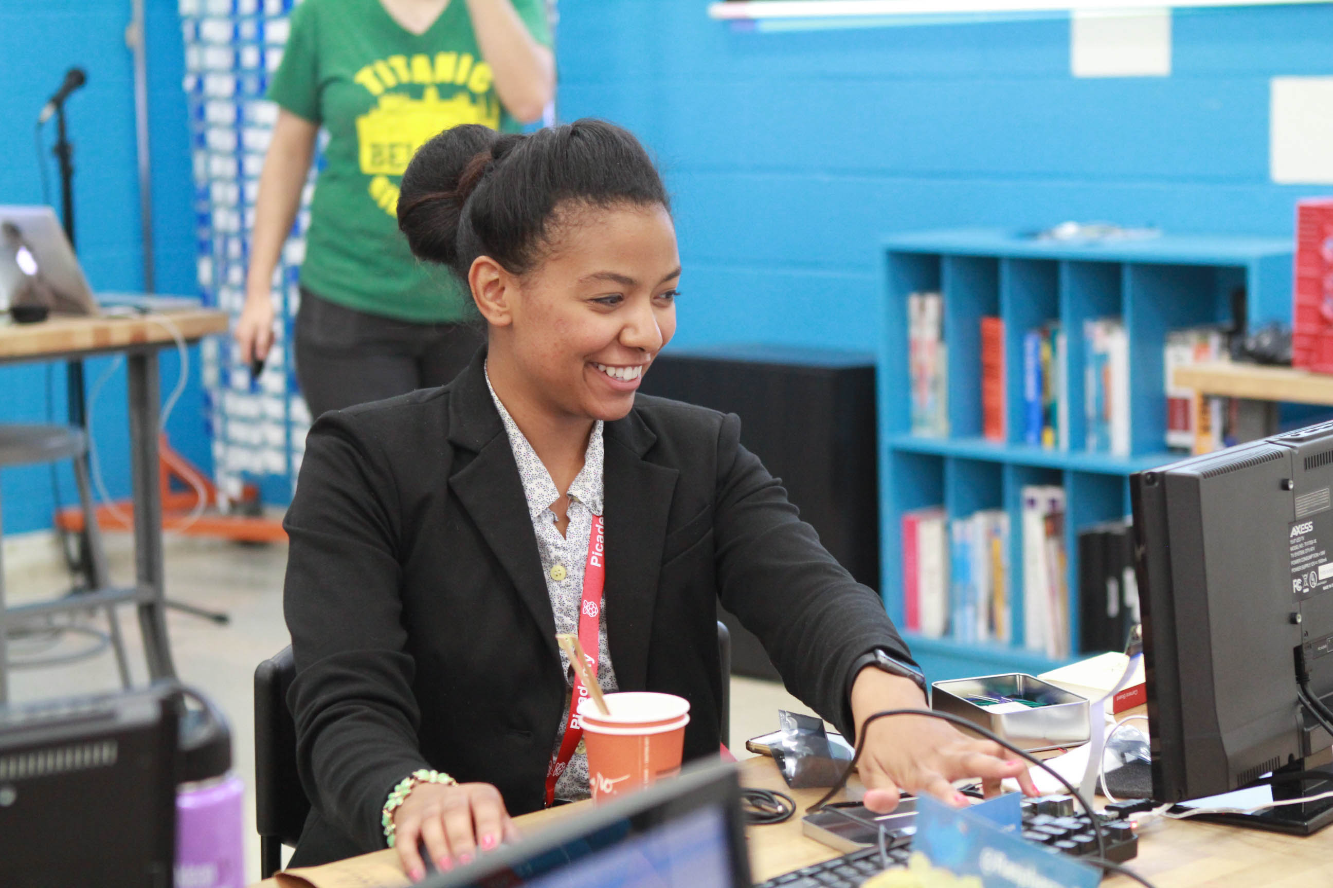 A smiling teacher at a computer