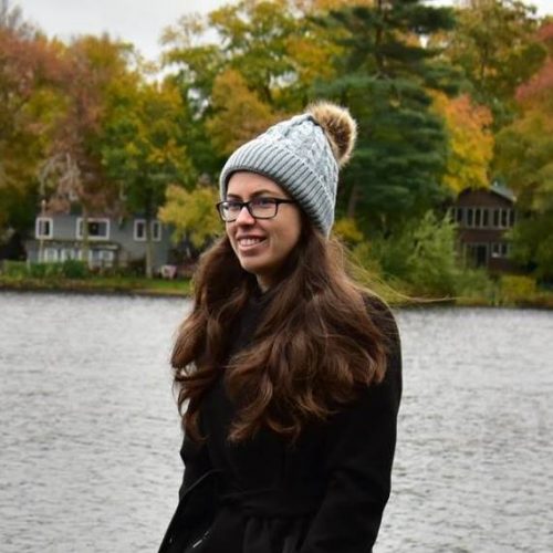 A woman with long brown hair wearing a wooly hat