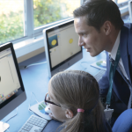 Male teacher and female student at a computer