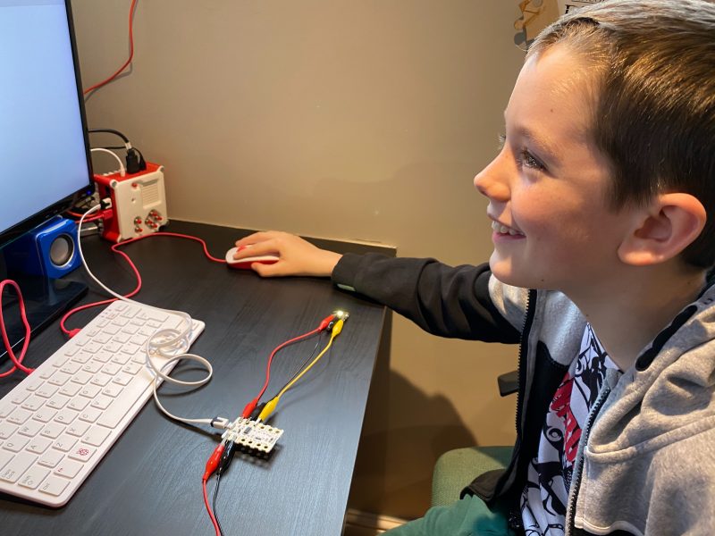 A child having fun with digital making at home using a Crumble controller