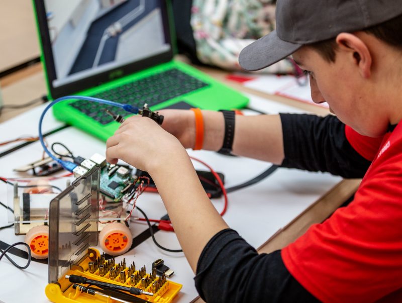 A boy working on a Raspberry Pi robot buggy