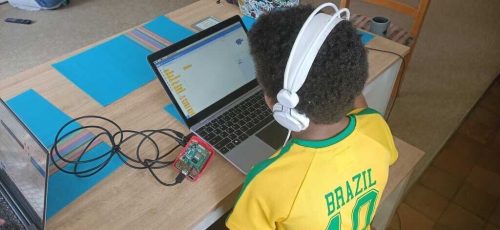 A young person programming in Scratch on a laptop.