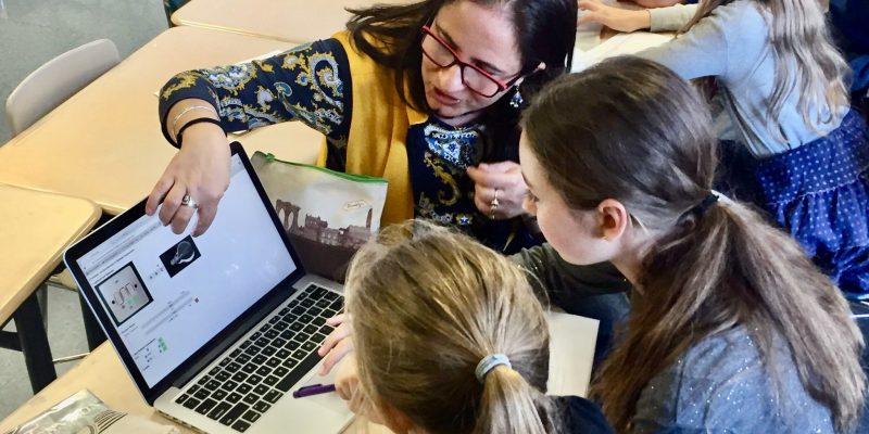 Shuchi Grover showing children something on a laptop screen