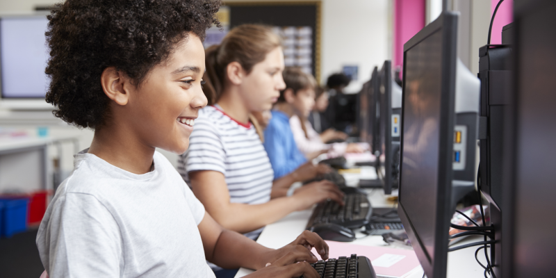 A computing classroom populated by students with diverse genders and ethnicities