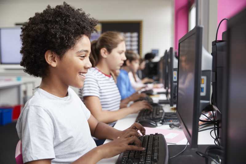 A computing classroom populated by students with diverse genders and ethnicities