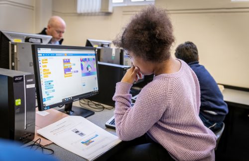 A girl doing Scratch coding in a Code Club classroom