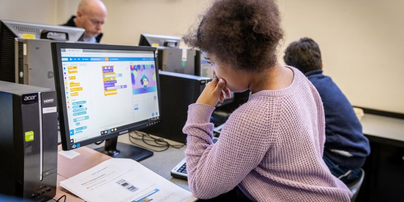 A girl doing Scratch coding in a Code Club classroom