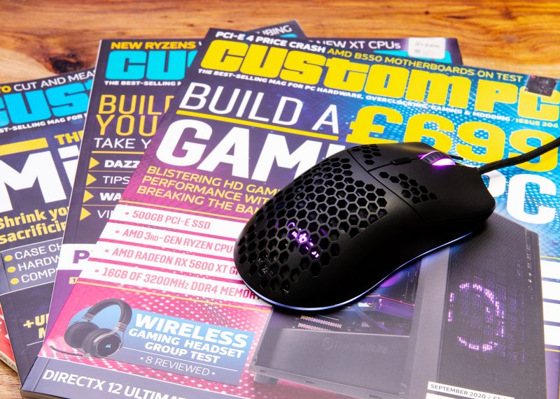 Some Custom PC magazines fanned out with the free giveaway mouse on top of them
