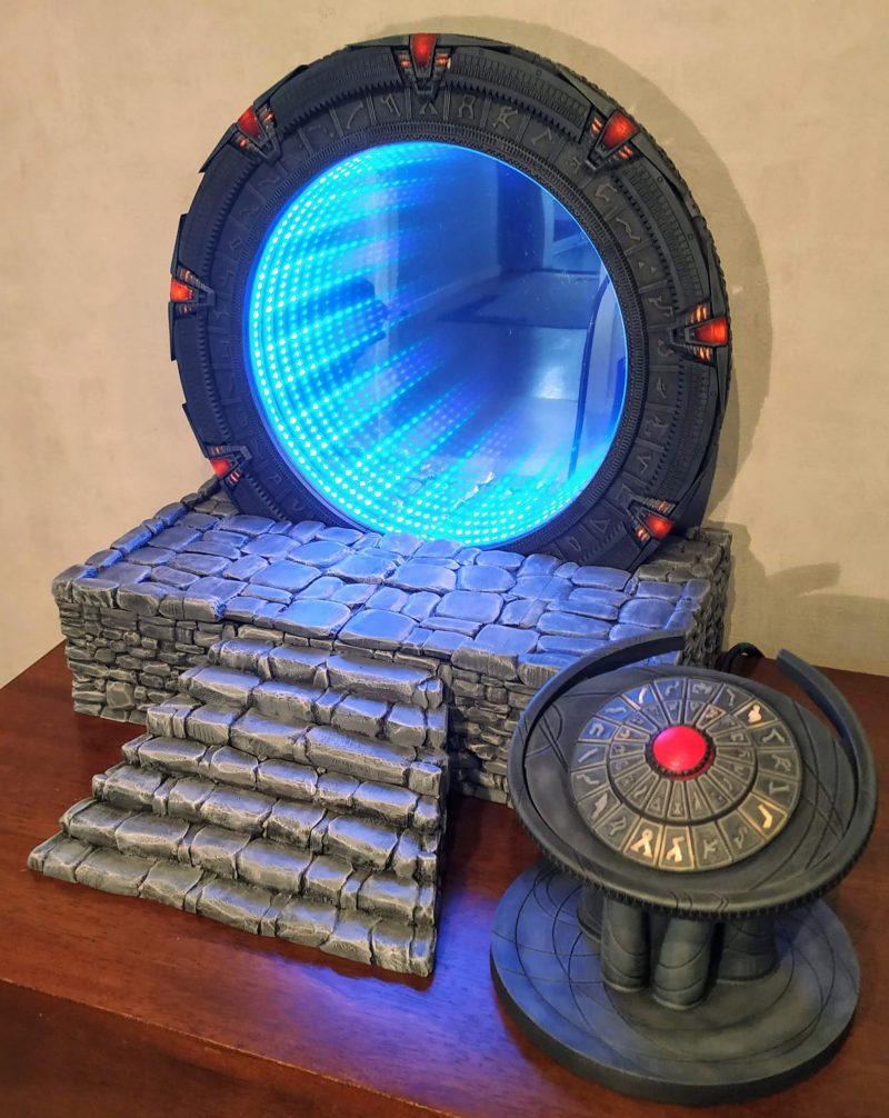 A mini version of the Stargate from TV sat on a table. Blue glowing light emits from the fake tunnel