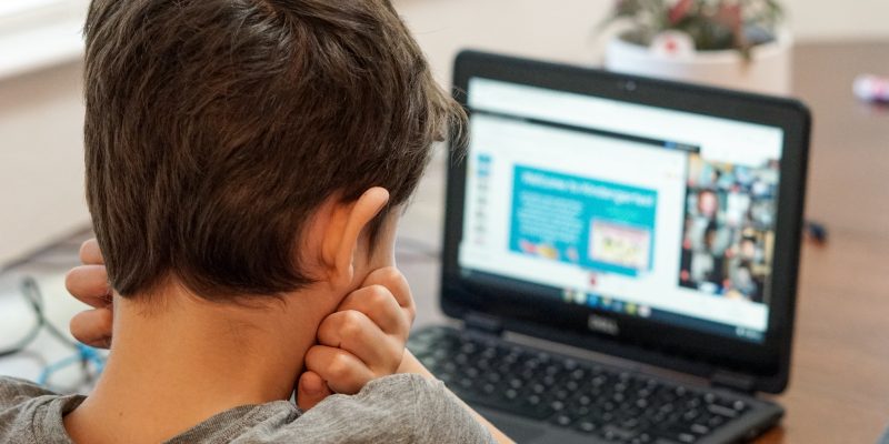 A child attending a remote learning session at a laptop