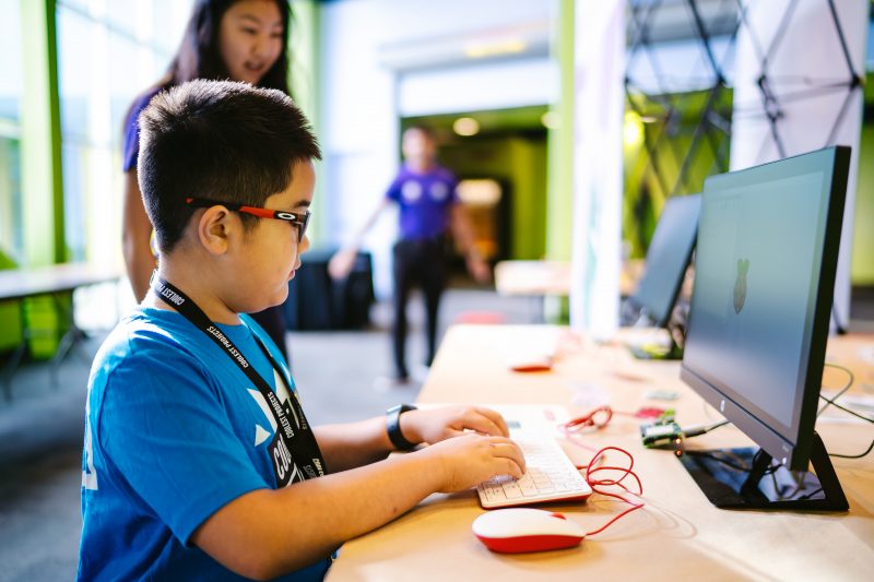 A boy using a Raspberry Pi desktop computer to code