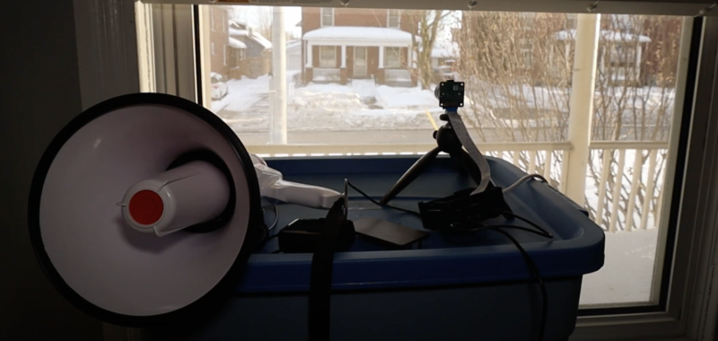 Raspberry Pi camera pointing out of a window connected to a megaphone which will announce when a dog passes by