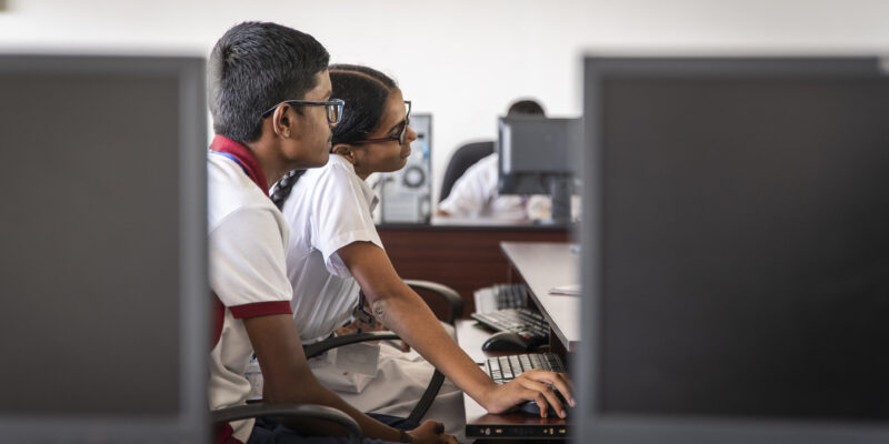 A girl and boy in India learning at a computer
