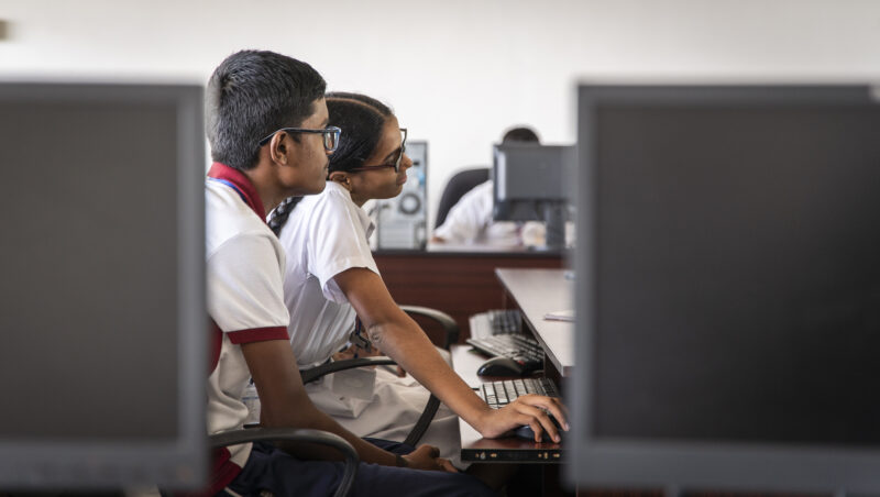 A girl and boy in India learning at a computer