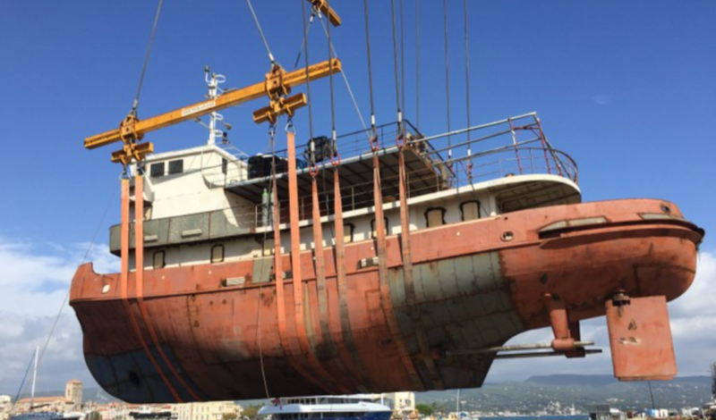 restored boat being pulled out of water before any work had been done on it