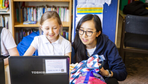 Teacher and young student at a laptop.