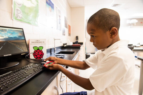 ילד שחור משתמש במחשב Raspberry Pi בבית הספר.