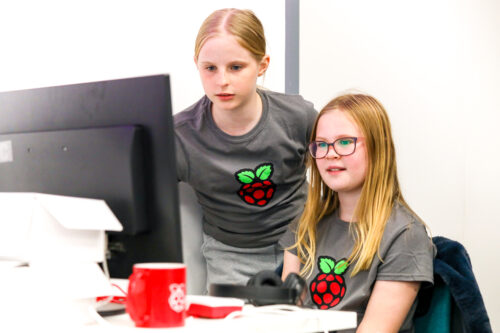 Two girls work together on a coding project.