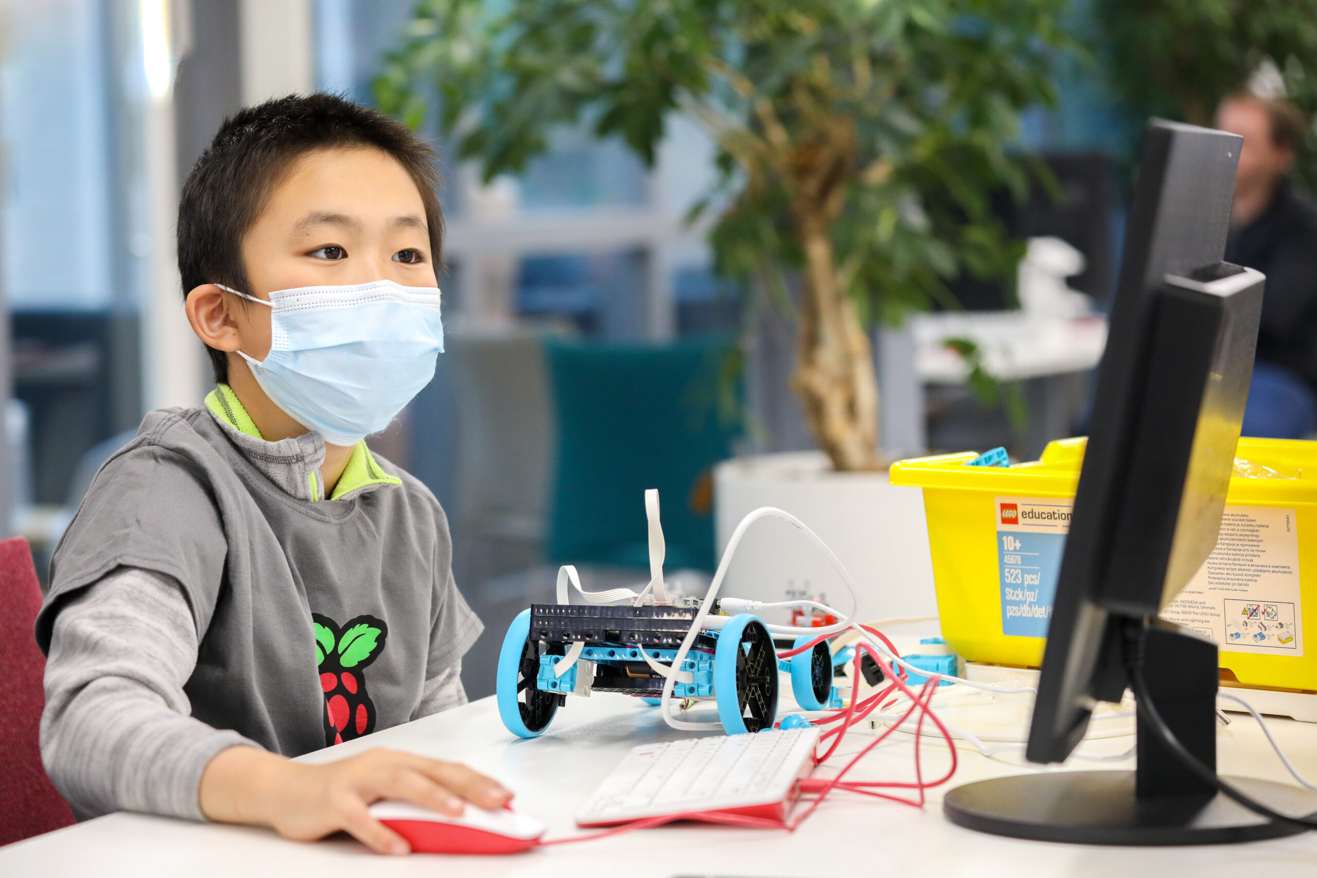 A young person builds a robot buggy with LEGO bricks and the Raspberry Pi Build HAT.