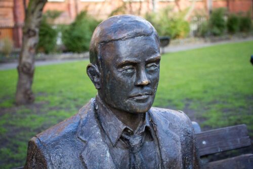 A statue of Alan Turing on a park bench in Manchester.