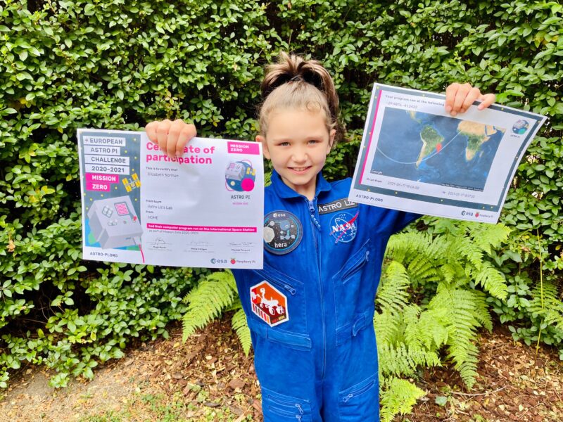 A young person holds up her Astro Pi Mission Zero certificate.