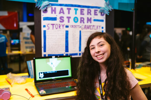 A teenage girl participating in Coolest Projects shows off her tech project.