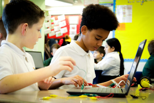 Two learners do physical computing in the primary school classroom.