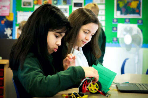 Two learners do physical computing in the primary school classroom.