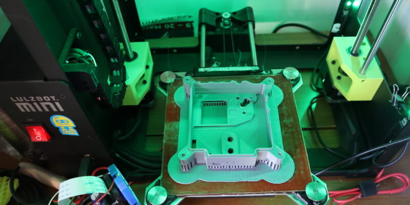 An Astro Pi case front is being printed on a 3D printer.