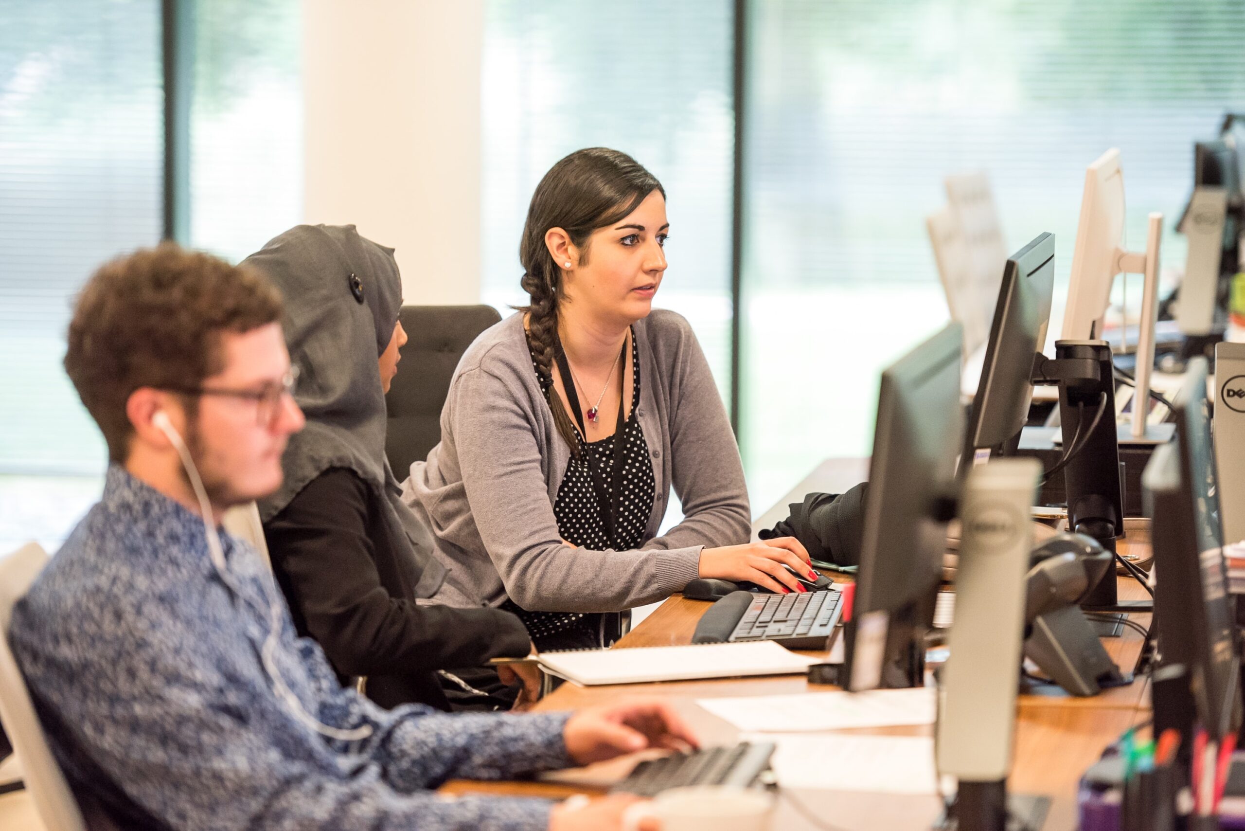 Two women work together at a computer.