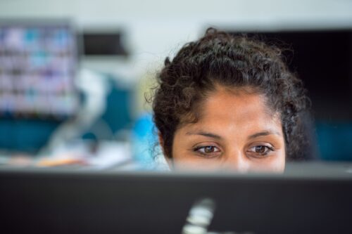 A women looks at a computer screen.