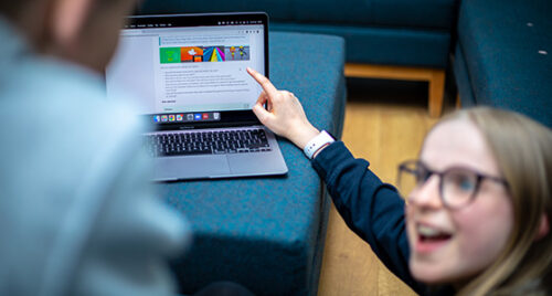 A girl points excitedly at a project on the Raspberry Pi Foundation's projects site.