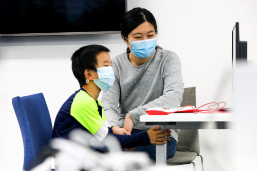 A parent and child work together at a Raspberry Pi computer.