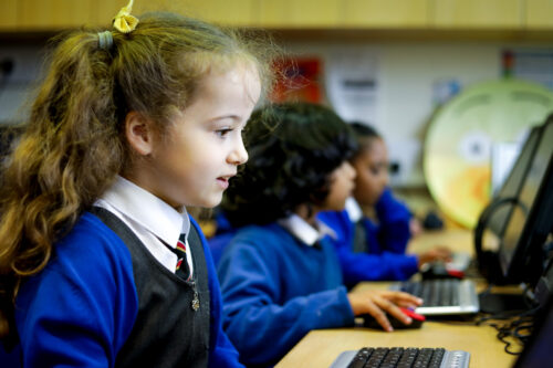 In a computing classroom, a girl looks at a computer screen.