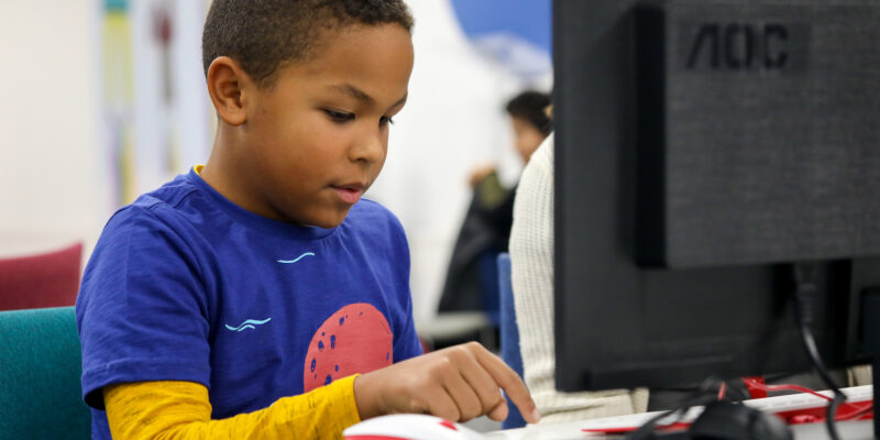 A boy types code at a CoderDojo coding club.
