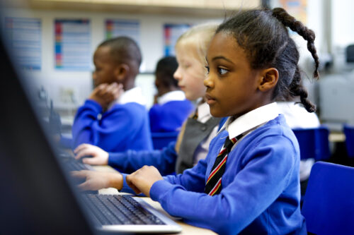 In a computing classroom, a girl looks at a computer screen.