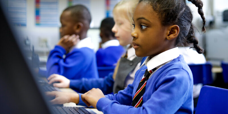 In a computing classroom, a girl looks at a computer screen.