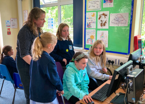 A teacher and four learners at a Code Club session.