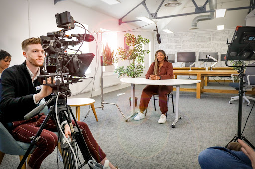 A videographer preparing to film a course presenter. 