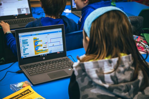 Child using Scratch on a laptop.  