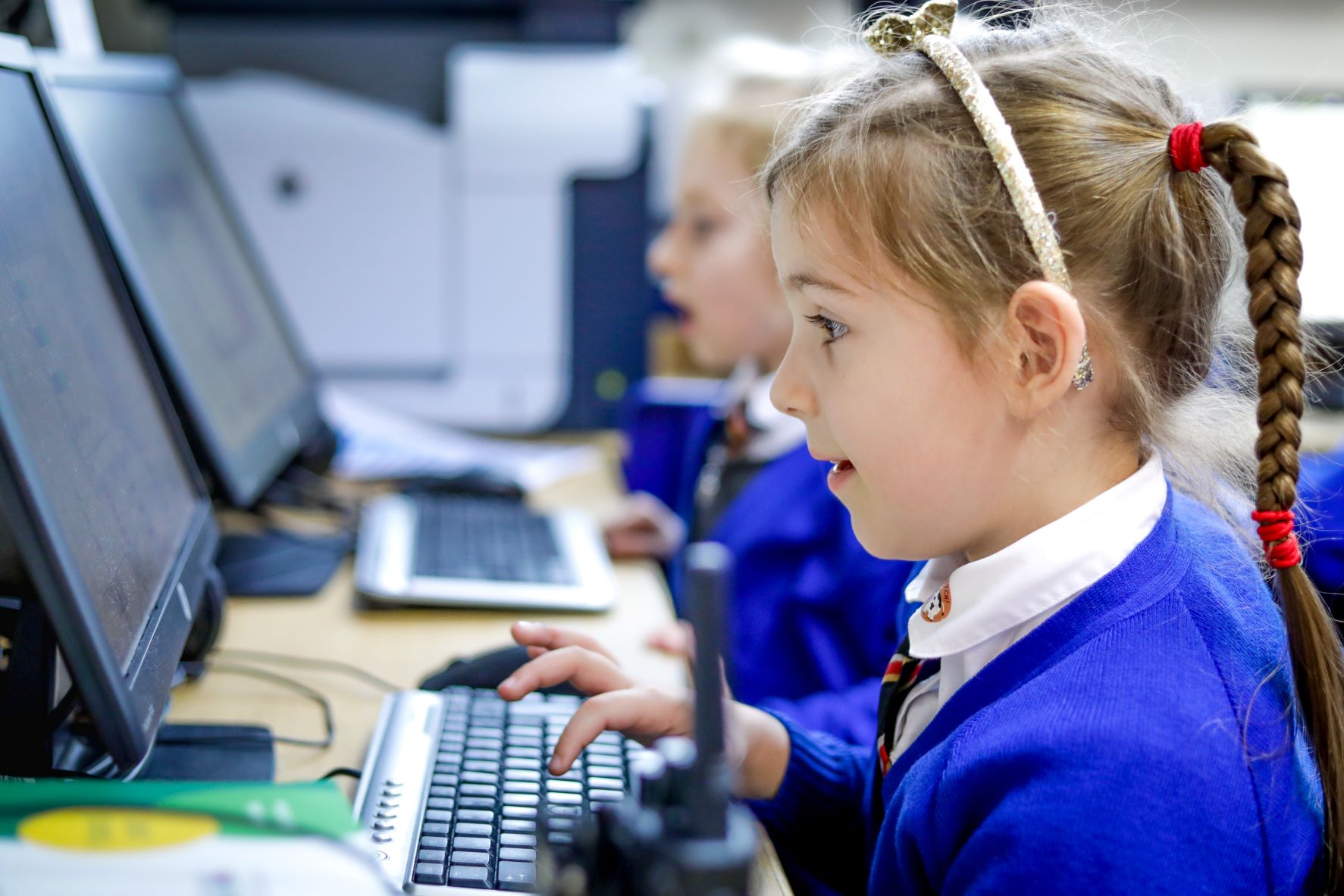 Girls writing programs on their computers.