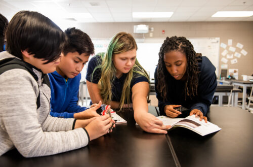 Young people work together to investigate computer hardware.