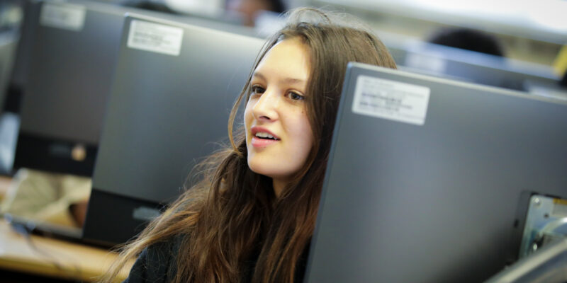 A young person in a university computing classroom.