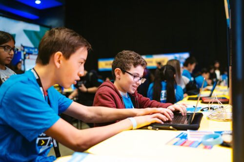 Two young people working together on a tech project.