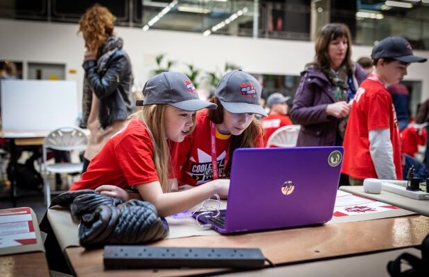 Two young people share a laptop at a Coolest Projects event.