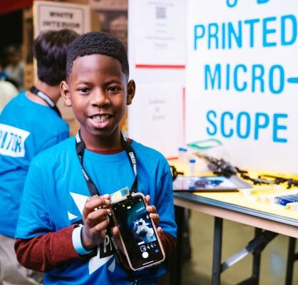 A young person with their project at a Coolest Projects event.